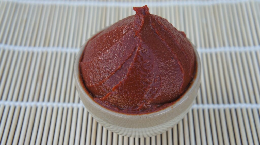 kochujang, a red and thick bean paste in a cup