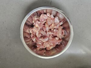 Raw chicken in bite-sized pieces in bowl