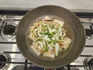 Fresh bok choy, tofu, and mushrooms in a pot.