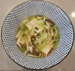 Tofu bok choy soup in a blue and white bowl