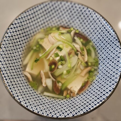 Tofu bok choy soup in a blue and white bowl