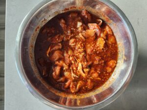 Raw chicken in spicy Korean sauce in a bowl
