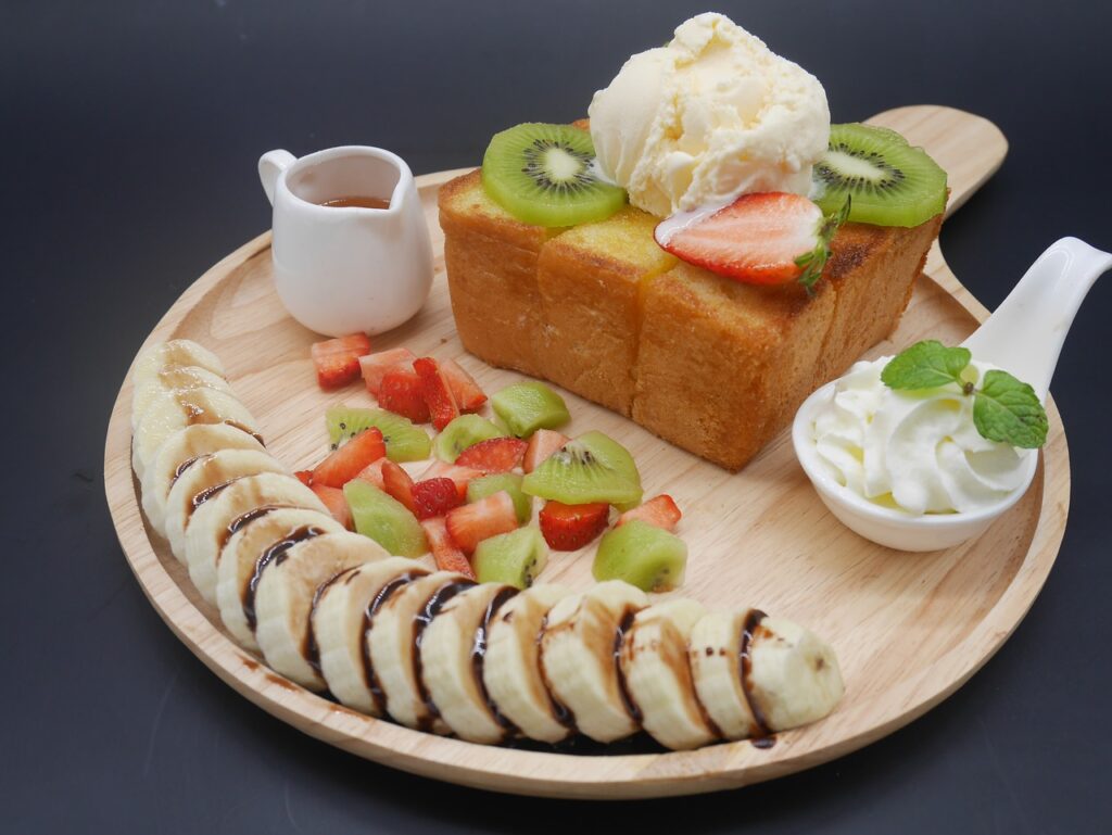 Thick honey butter toast decorated with fresh fruit and whipped cream. 