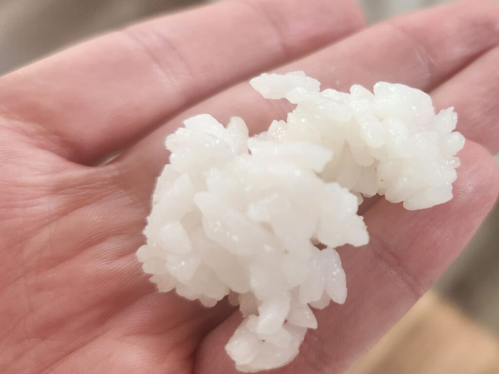 A picture of a small handful of fluffy white rice that is well cooked. 